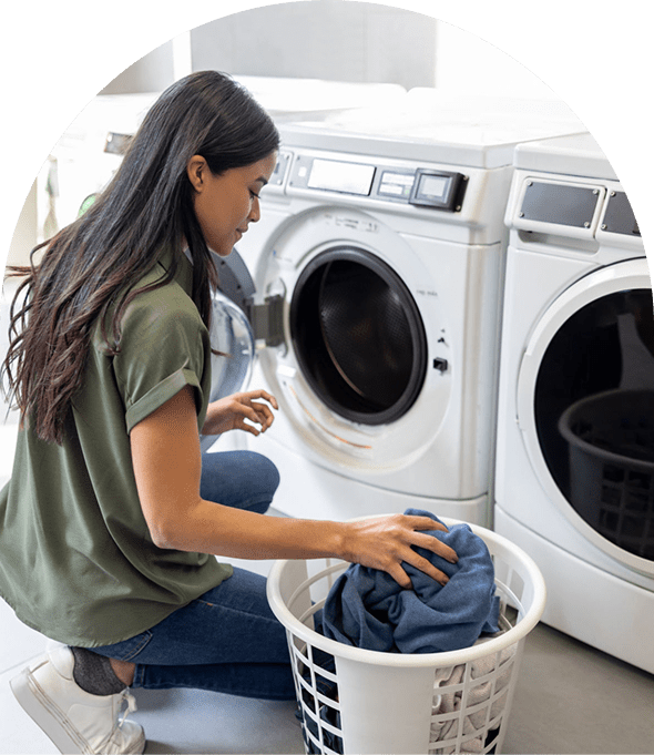 Woman loading laundry into washing machine