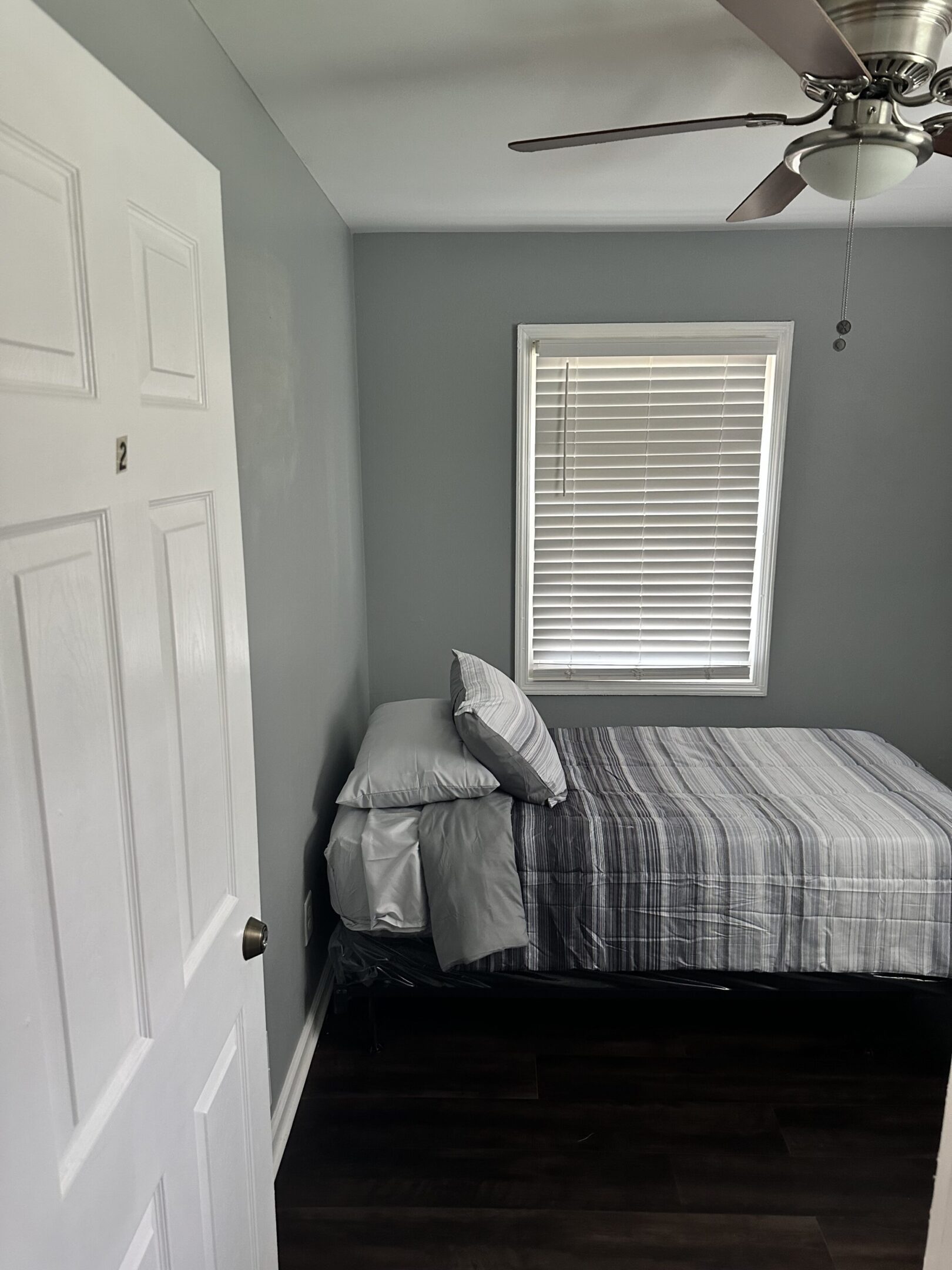 Small bedroom with gray walls and bed