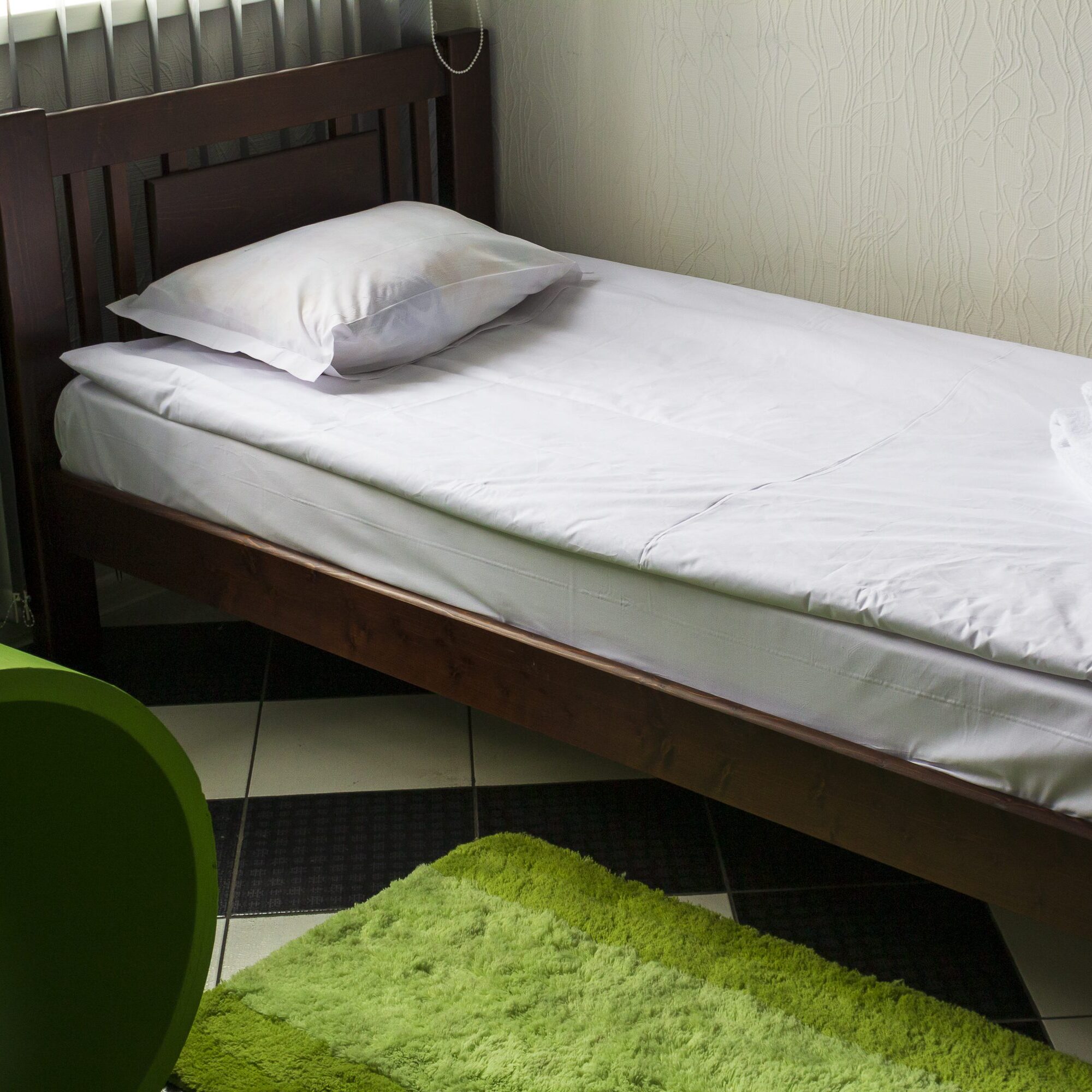 Bed for one person covered with white bedding, background. The need for quarantine and self-isolation